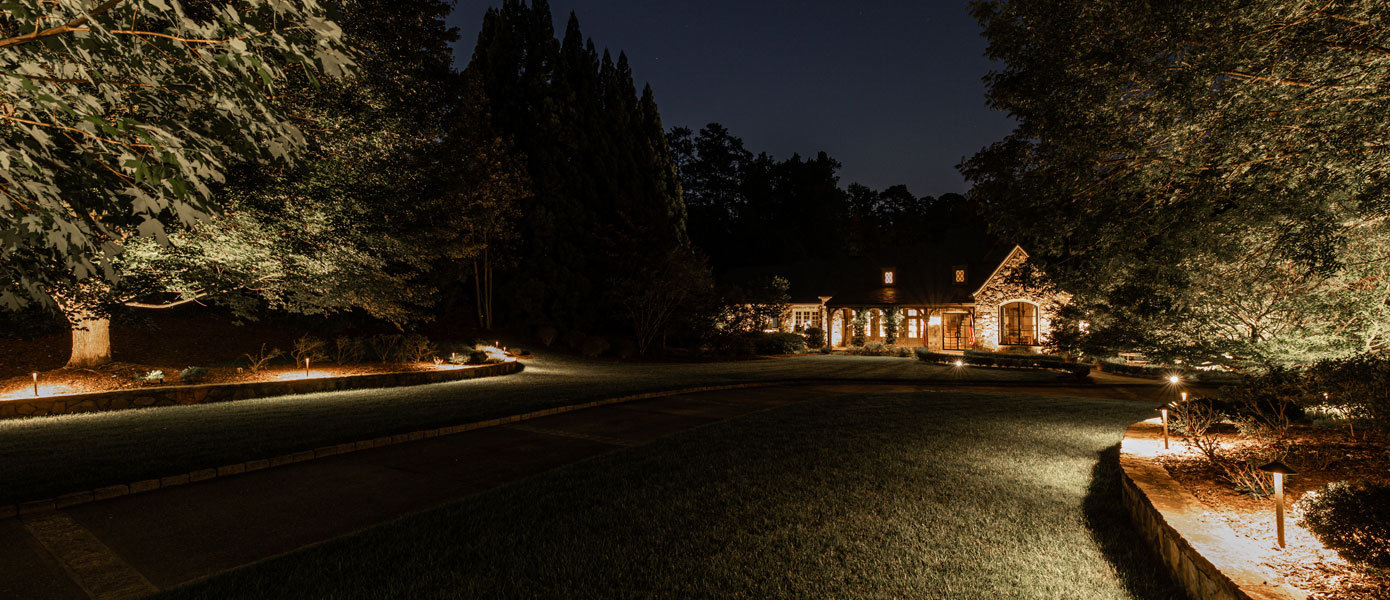 A house with lights on the side of the roadDescription automatically generated