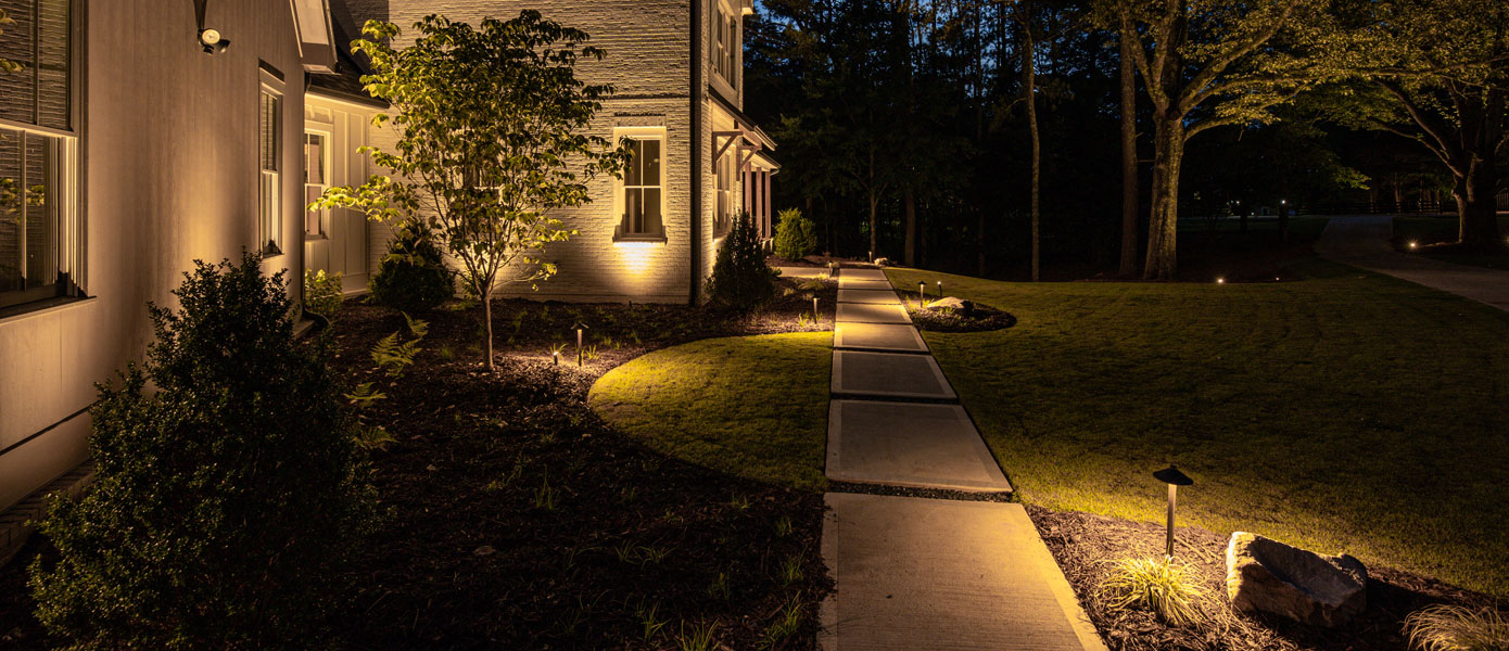 A walkway leading to a house at nightDescription automatically generated