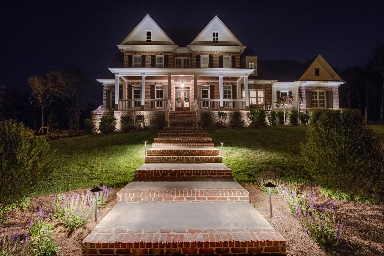 brick home with exterior lighting