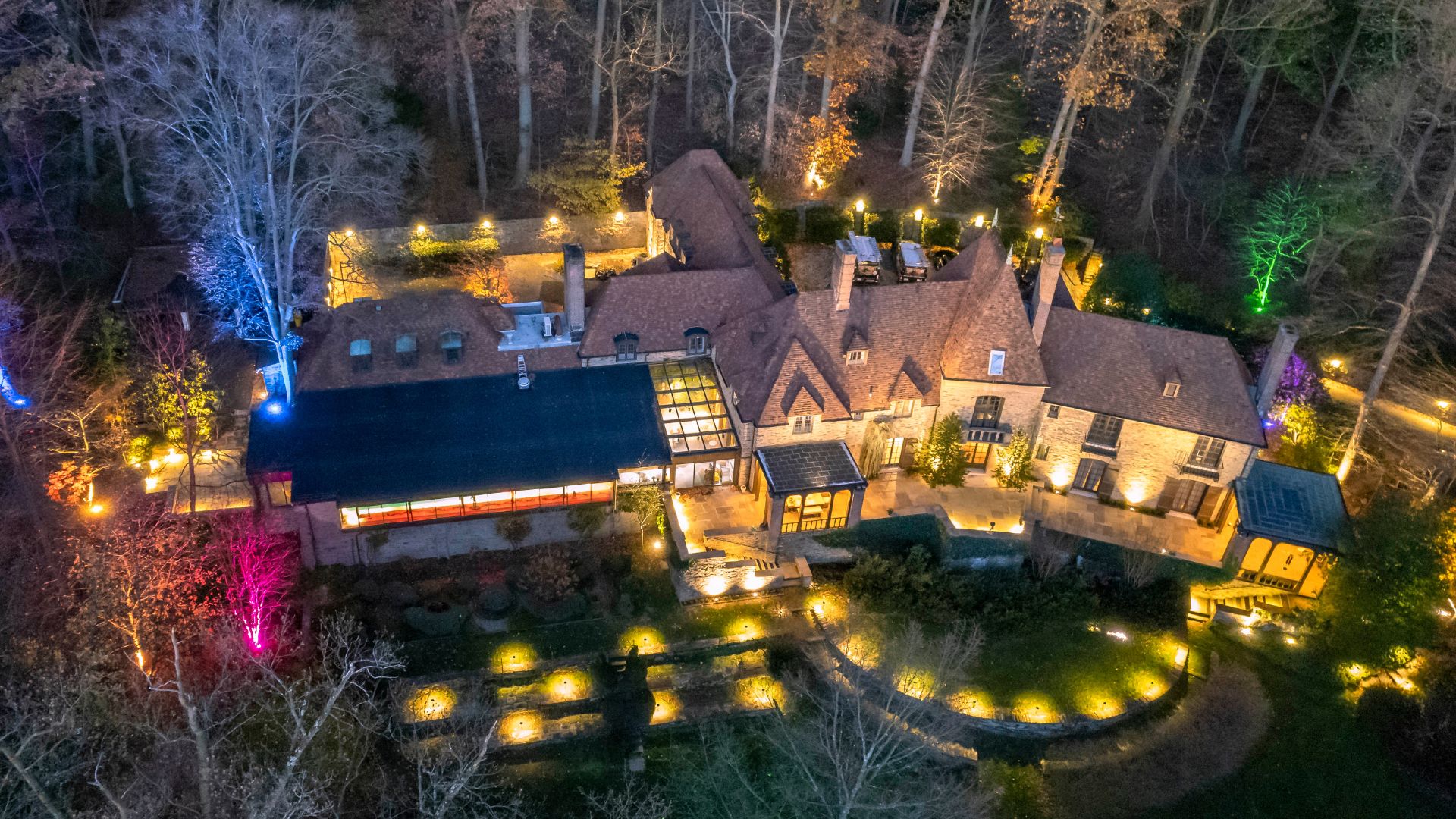 Areal view of home with outdoor lighting