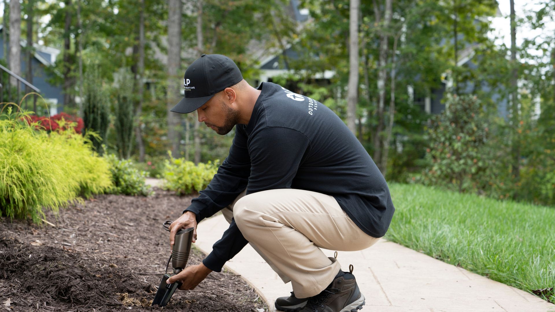 man putting in lights in landscaping