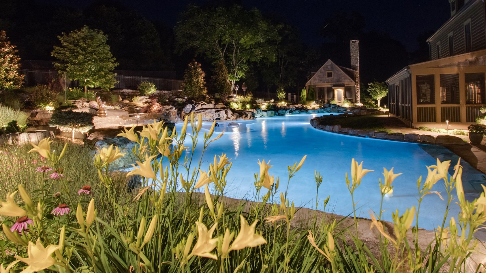 pool with outdoor lighting and landscaping