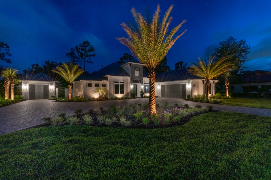 front yard illuminated with outdoor lighting