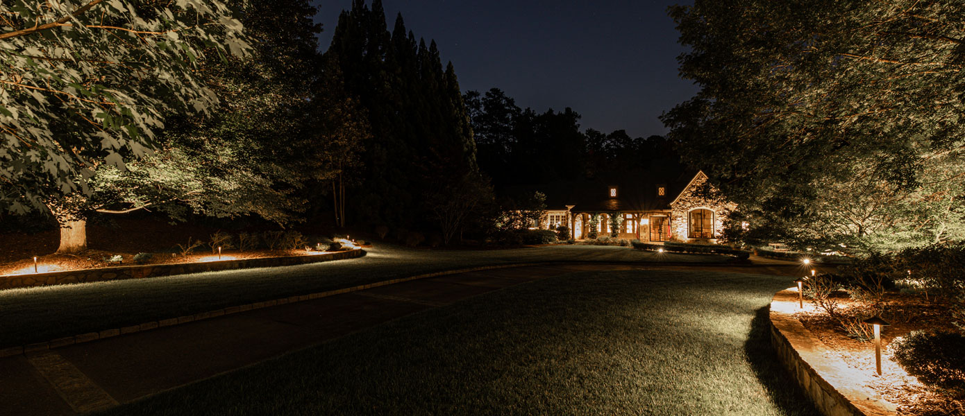 A house with lights on the side of the roadDescription automatically generated