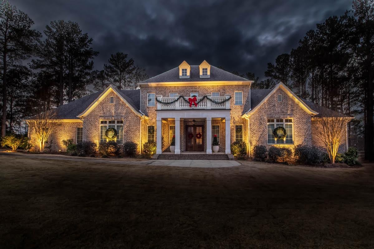 front of a house lit up with Christmas decorations