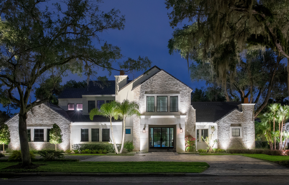 front yard illuminated with outdoor lighting