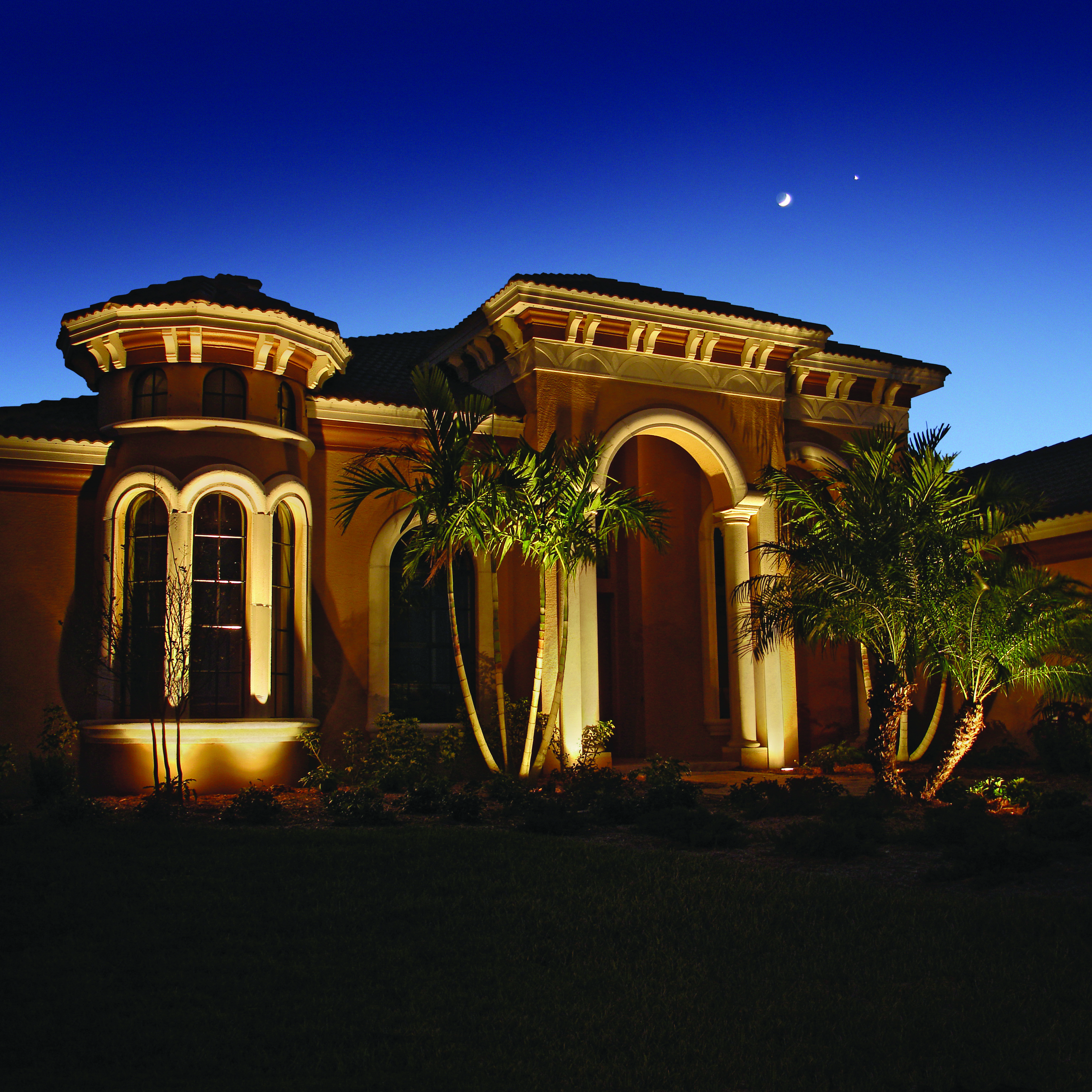 Miami home illuminated at night by outdoor lights.