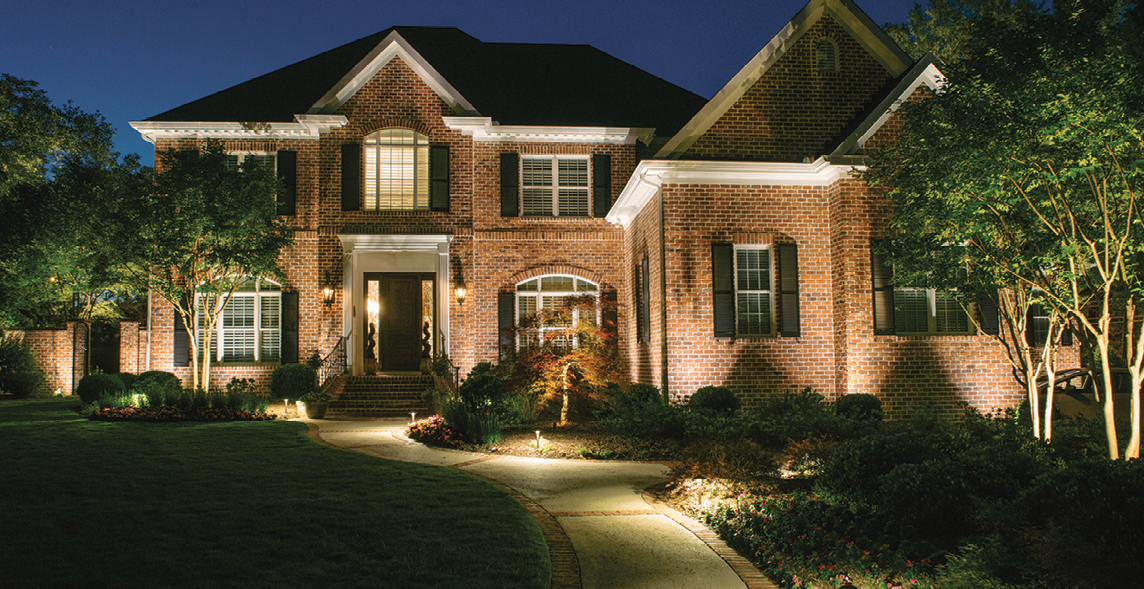 front yard illuminated with outdoor lighting