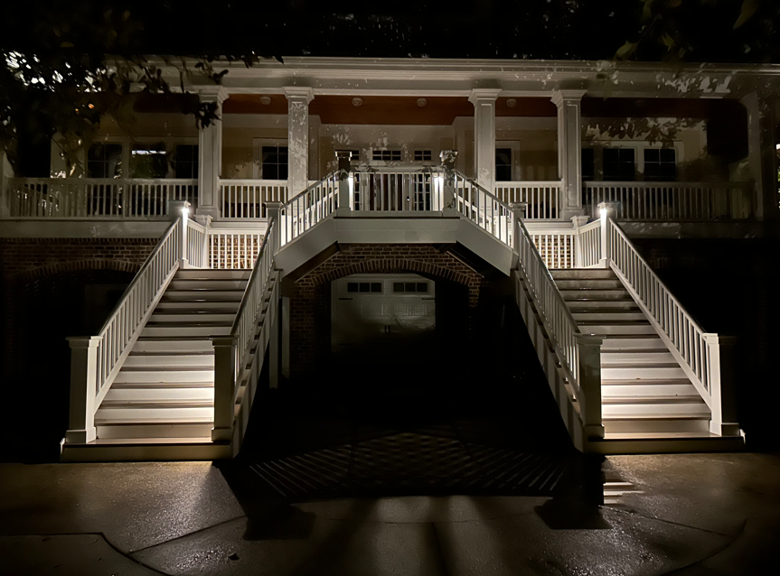 front yard illuminated with outdoor lighting